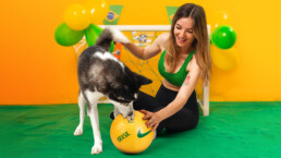 mulher-sentada-brincando-com-cachorro-tema-futebol-brasil